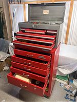 Gray Craftsman top chest open and red Dayton bottom chest with drawers open showing tools