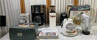 Photo of the entire collection showing Mr. Coffee drip coffee maker, Juicextractor juicer, blender, Hamilton Beach can opener box, kitchen scale, and other smaller kitchen appliances.