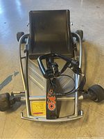 Front view showing black plastic seat, silver frame, T-handle steering and front wheels.