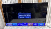 Front view of the Vizio M43-C1 TV powered on, showing smart TV interface with network disconnected message across bottom.