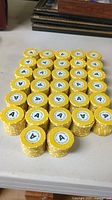 Top down view of 320 yellow casino grade poker chips stacked in groups on a table.