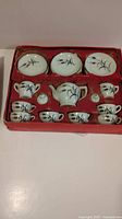 Complete vintage Little Duchess china tea set arranged in original red cardboard insert showing all pieces.