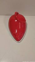 Top view showing the smooth, shiny red ceramic cover shaped like a mouse with ears and face detail.