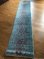 Full view of Safavieh Monaco carpet runner laid out on wooden floor, showing the complete length and pattern in blue tones.