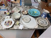 Full set of Royal Doulton china including pitcher, bowls, plates, floral basket with chipped flowers, and platter on kitchen counter.