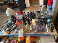 Full view of assorted flashlights, lanterns, and walkie talkies arranged on a table.