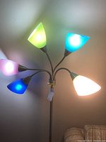 Floor lamp with six colored glass shades lit up showing pink, green, blue, teal, and white colors.