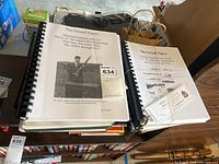 Front view of two spiral-bound Garand Papers books stacked together with a visible cover showing a historical photo of John C. Garand holding an M1 Garand rifle.