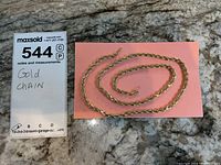 Full view of rope chain laid out next to lot card