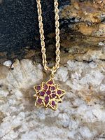 Close-up of star-shaped pendant and rope chain on stone background
