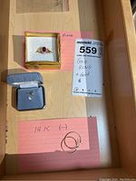 Drawer with ring in box, note card, stud in small box, hoop earrings on pink card