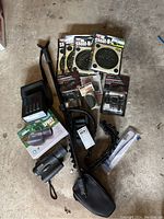 Full lot overview showing night vision scope, monopod, targets, laser sight kits, timer, belt, and ring mount.