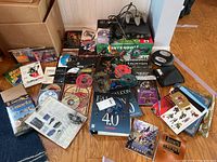 Wide overview showing console, box, controllers, cables, game cartridges and PC software items laid out.