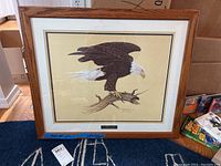 Full view of the framed eagle print artwork showing wood frame, matting, and mounted print.