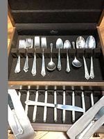 Wooden case open showing top tray of forks and spoons and lower drawer of knives