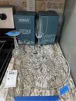 Photo showing two Marquis Vintage champagne flute boxes, champagne flute, and Waterford crystal serving plate on kitchen counter.