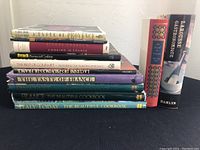 Stack of 10 cookbooks featuring French and Italian dishes, titles visible on spines and front covers.