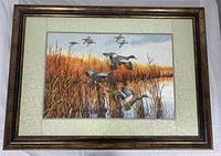 Full view of framed silk embroidery art with six ducks flying over a marsh with golden reeds and water.