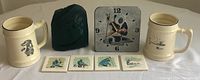 Soapstone clock, etched stone clock, mugs, and four small ceramic tiles with Inuit designs