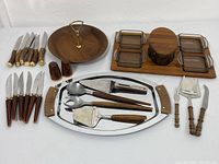 Full array of serving and cutlery items including wooden trays, glass ramekins, steak knives, salt & pepper shakers, and serving utensils.