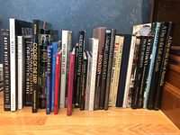 Photo of 21 photography books lined up on a wooden surface showing various titles including Karsh, America's Countryside, Toronto, and others