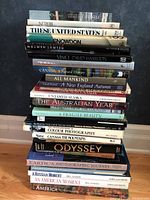 Stack of photography and nature books on the floor against wall showing titles and condition