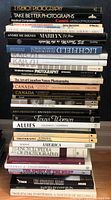 Stack of assorted photography books including French Photography, Take Better Photographs, Canon World Photography, Beauty & Glamour Photography, and others.