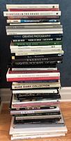 Stack of approximately 20 photography and art books showing titles and spines, depicting various artistic photographic themes and authors.