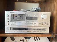 Front view of Sony stereo cassette deck TC-K77R and FM stereo FM-AM tuner ST-J55 stacked.