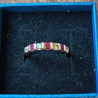 Overhead view inside presentation box showing alternating baguette rubies and round diamonds