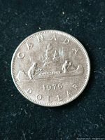 Obverse side of the 1976 Canadian one dollar coin showing the birch bark canoe and northern lights design with inscriptions 'CANADA 1976 DOLLAR'.