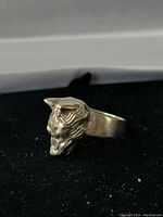 Front angle showing detailed wolf head face with open mouth and textured fur on sterling silver ring.