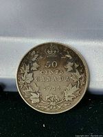 Reverse side of 1919 Canadian 50 cent coin displaying denomination, maple leaf wreath and crown.