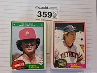 Close-up photo showing two baseball cards from the 1981 O-Pee-Chee series featuring Steve Carlton from the Phillies and Alan Trammell from the Detroit Tigers.