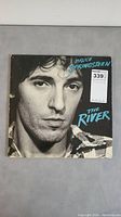 Front cover of Bruce Springsteen The River vinyl album showing black and white close-up photo of Bruce Springsteen's face and album title.