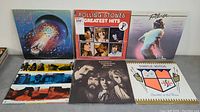 Photo showing 7 vinyl LP covers including Electric Light Orchestra 'Time', Rolling Stones 'Greatest Hits', and Footloose soundtrack
