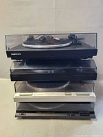 Stacked front view of all four turntables with dust covers down