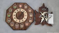 Wooden octagonal clock with Canadian city crests and clock face showing 'Canada' text in center