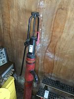 Full view of the antique hand pump on wooden post showing overall height and condition.