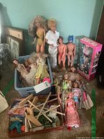 Overview of standing dolls, storage bin, loose dolls, boxed Barbie