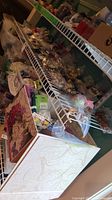 Photo showing wire shelving filled with bins and boxes containing various beads, crafting supplies, and tools.
