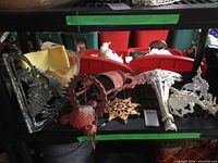 Shelf with various cast iron items including lamp holders, legs, planter, and shelf brackets, along with a glass bowl.