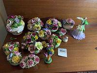 Group overview of all floral and bird figurines showing variety and quantity.