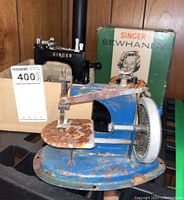 Blue Singer Sewhandy childrens sewing machine with significant rust and original box behind it