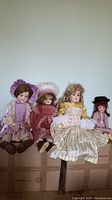 Four dolls seated on cardboard boxes