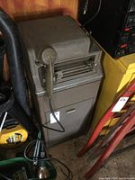 Full view of the gray metal voicewriter cabinet with handset and drawer, showing overall size and wear.