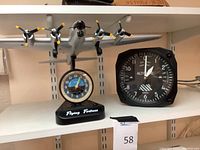 Full view of Flying Fortress model clock next to Trintec altimeter clock on shelf.