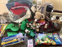 Overview of cookie cutters, oven mitts, towels, slow cooker liners, Ziploc bags, small electric kettle, thermal bottle, stainless steel kettle