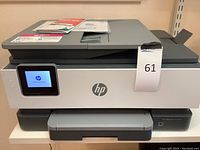 Front view of HP OfficeJet Pro 8025 printer powered on with touchscreen visible, showing device condition and model branding.