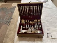 Open wooden chest showing complete flatware set laid out